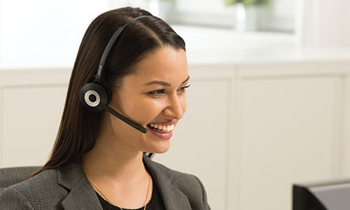 Woman at computer wearing Jabra Pro 920 headphones on a call