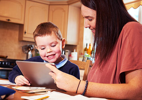 Young boy using device to learn from home